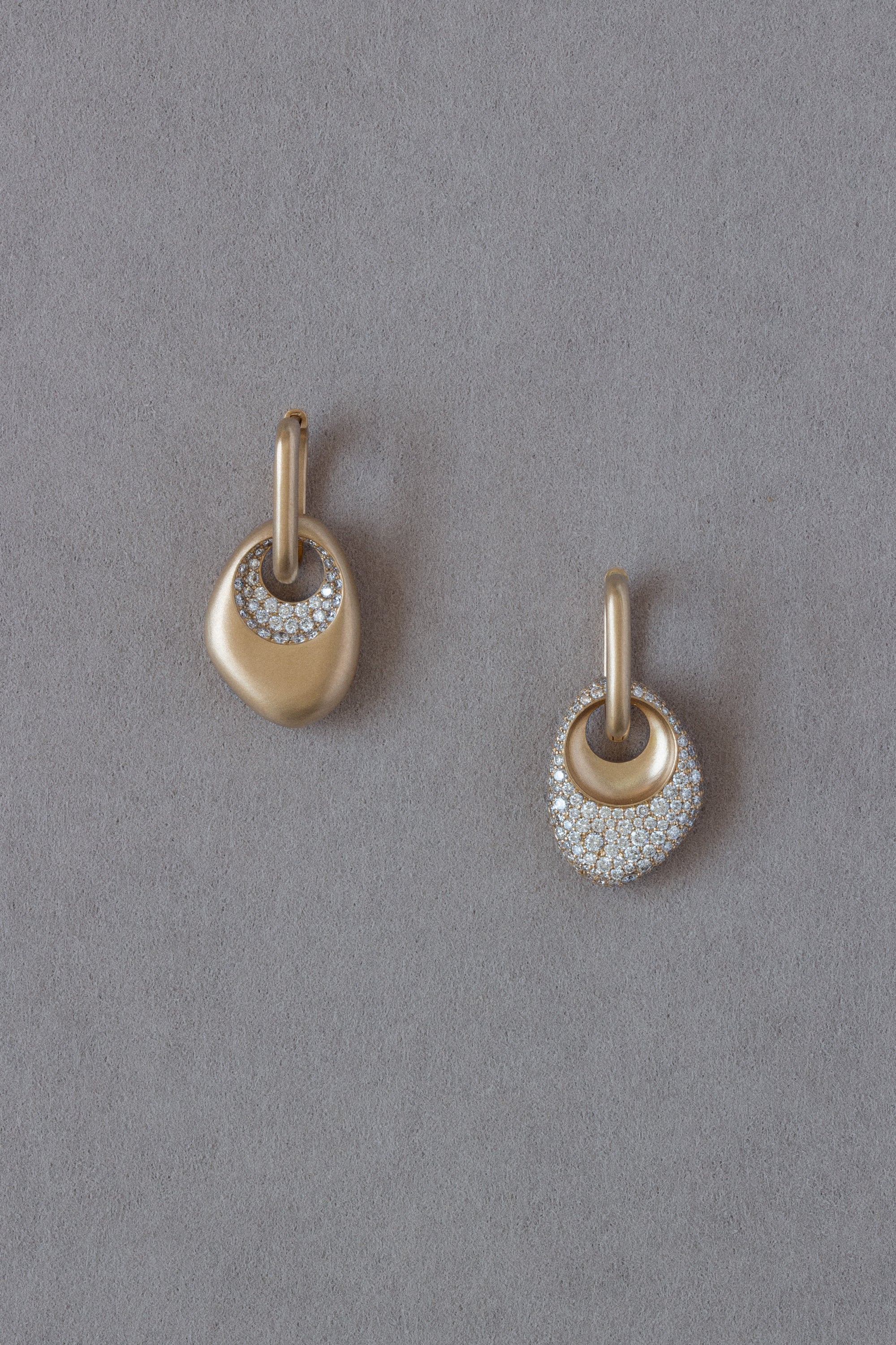 Pair of 18k Gold Egg Shaped Drop Earrings set with white diamonds on a grey background