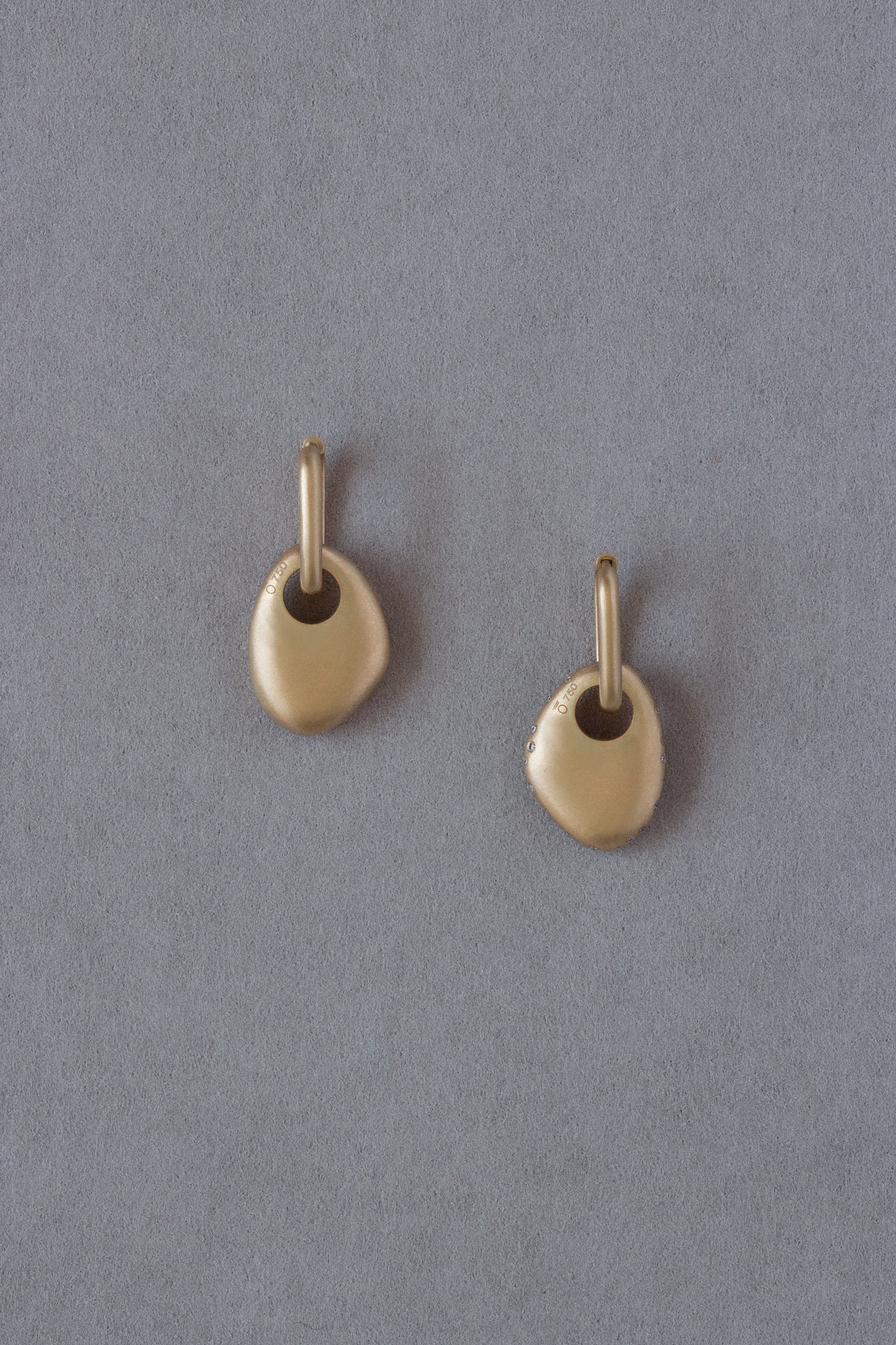 Pair of 18k Gold Egg Shaped Drop Earrings set with white diamonds back on a grey background
