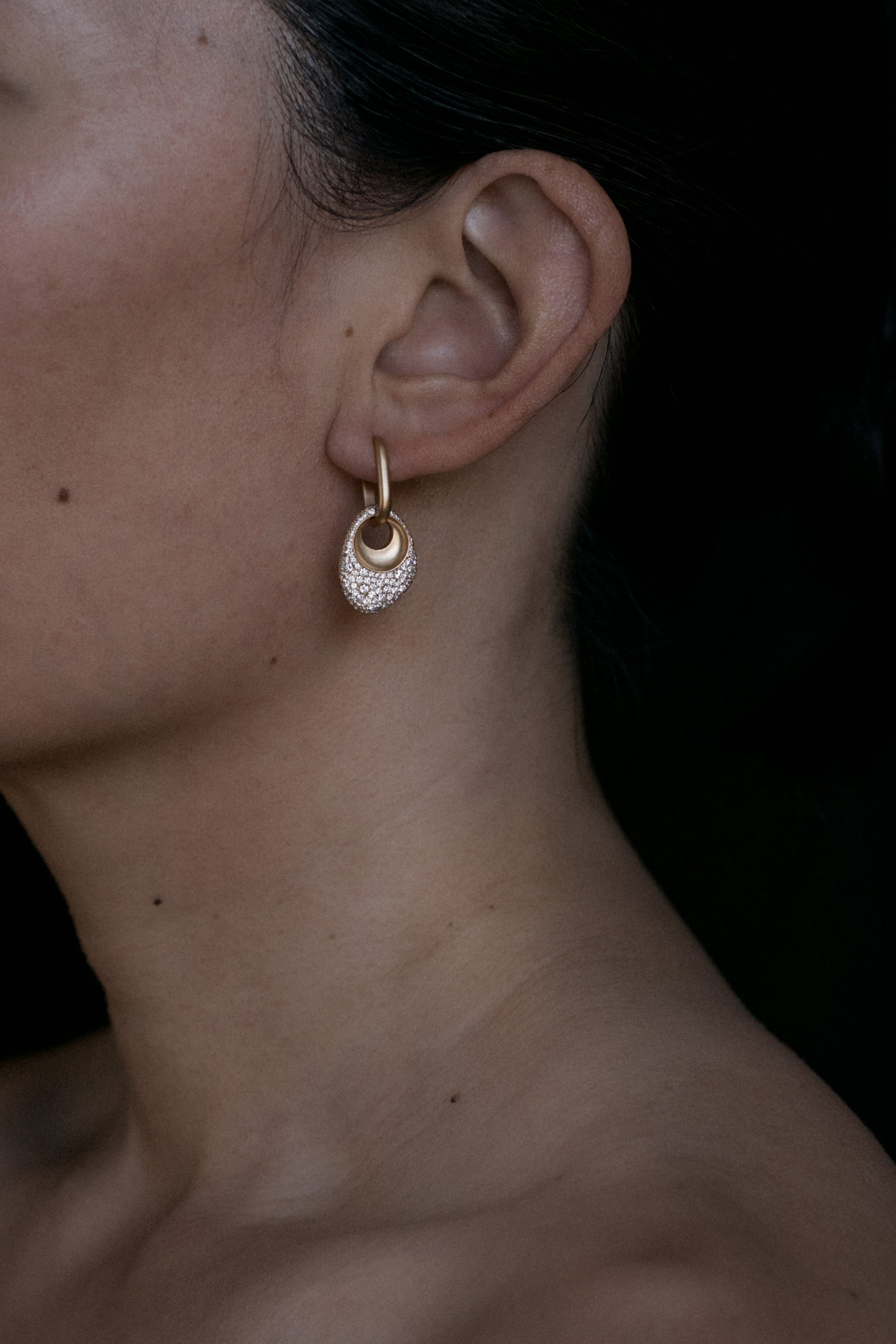 Pair of 18k Gold Egg Shaped Drop Earrings set with white diamonds on a grey background