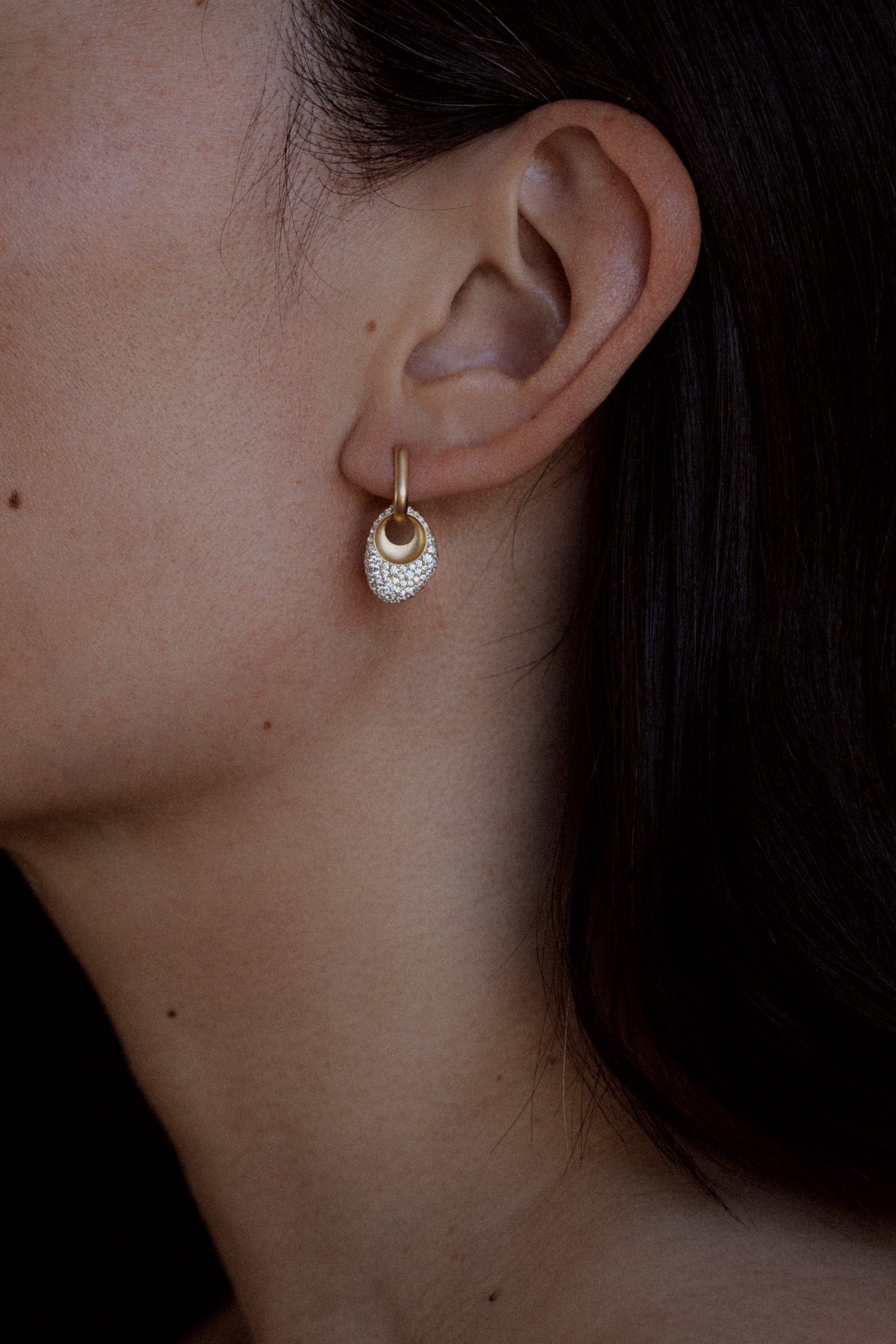 Pair of 18k Gold Egg Shaped Drop Earrings  set with white diamonds on model
