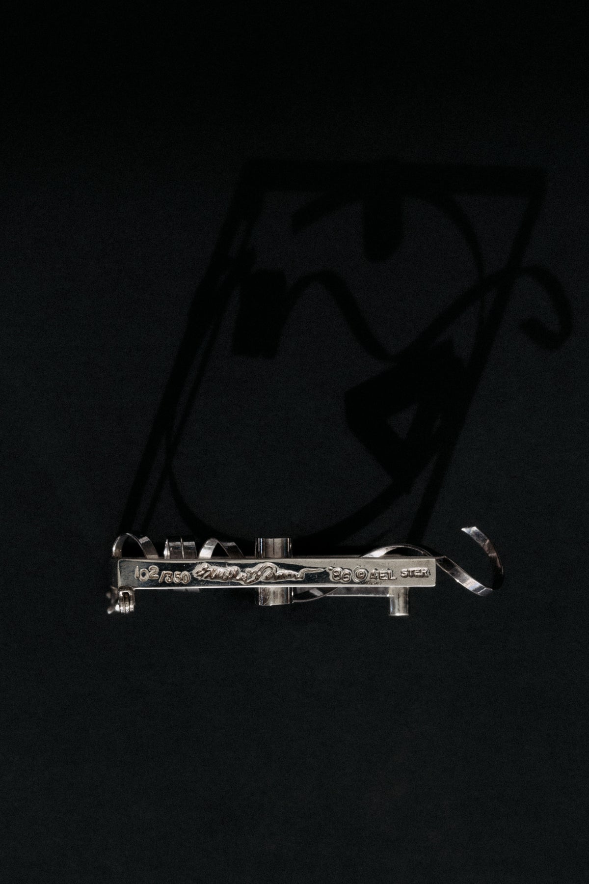Close-up of Fletcher Benton signature, date 1986 and STER AEL hallmark on sterling brooch