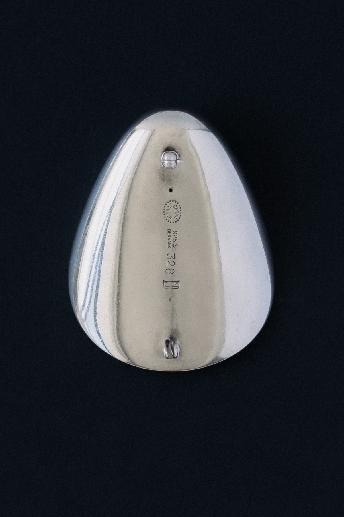 Close-up of Georg Jensen hallmark, 925 S, Denmark, 328, NJ stamped on sterling silver brooch