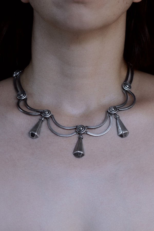 Model wearing vintage Los Castillo Taxco sterling silver pendulum necklace, mid-century Mexican modernist design