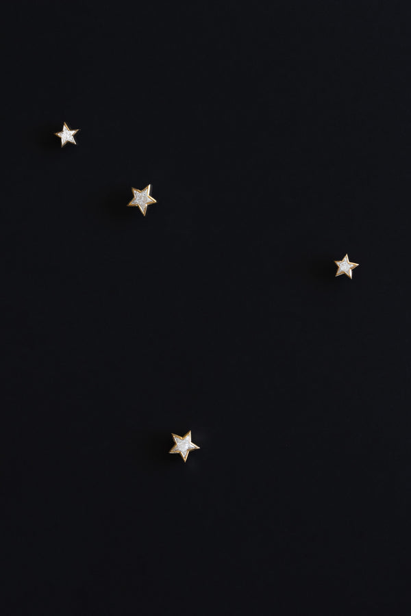 Ouvelle Custom cut star shaped white diamond earrings set in 18 karat yellow gold on black background