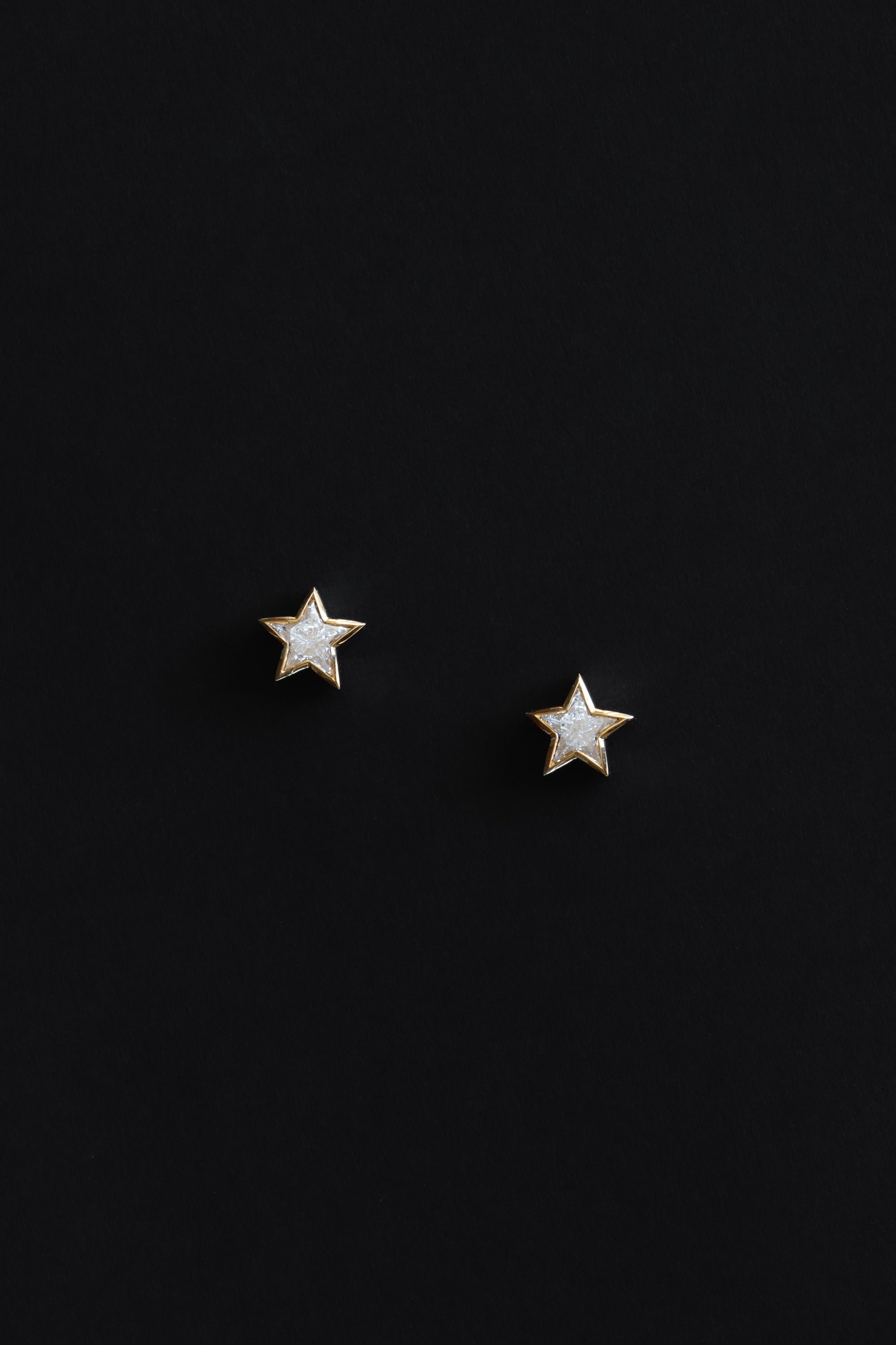 Ouvelle Custom cut star shaped white diamond small stud earrings set in 18 karat yellow gold on black backgroun