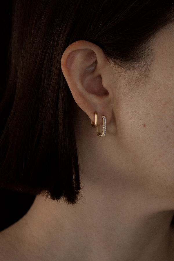 Ouvelle pair of gold and diamond pave rectangular rounded hoops on model ear