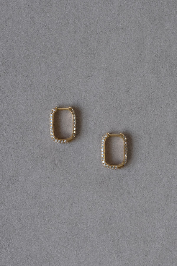Ouvelle pair of gold and diamond pave rectangular rounded hoops on grey background