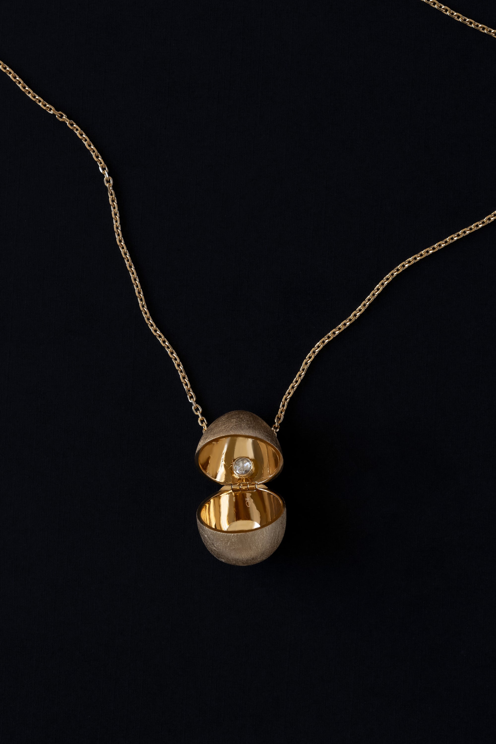 Egg shaped locket vessel necklace in 18k yellow gold with rose cut diamond inside