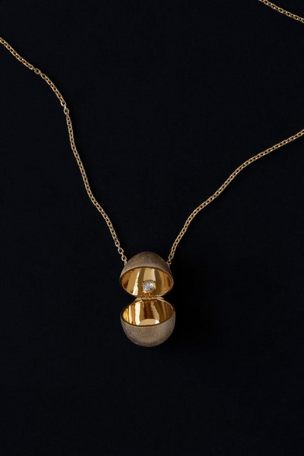 Egg shaped locket vessel necklace in 18k yellow gold with rose cut diamond inside