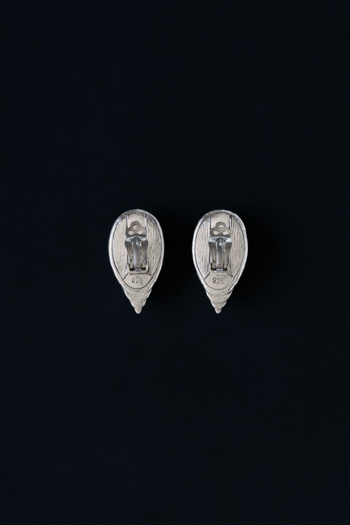 Back view of vintage fluted shell clip earrings showing clip mechanism and 925 hallmark