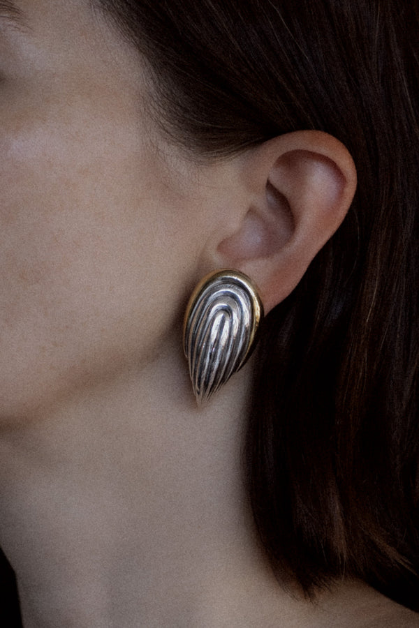 Vintage two-tone fluted shell clip earrings worn on model, shown at true scale