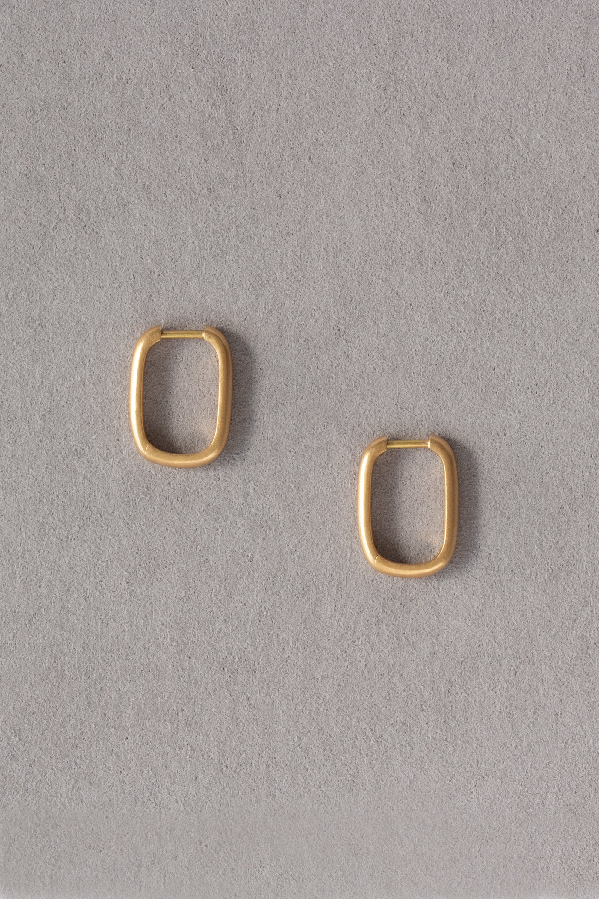 Rounded Edge Large 18k Gold Hoops On Grey Background